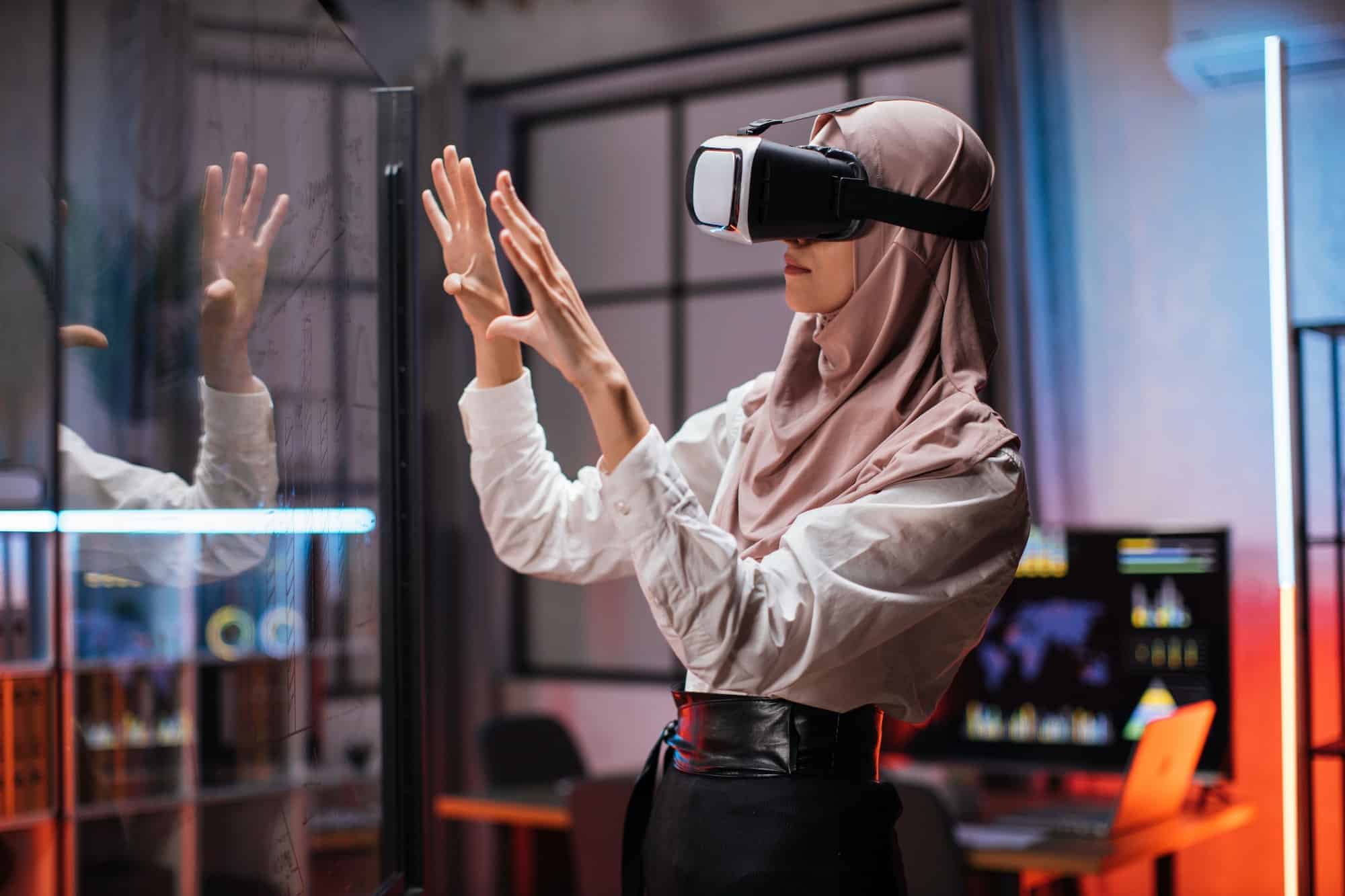 Confident muslim woman in hijab using innovative technology during business strategy 1