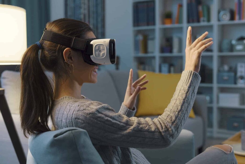 Woman wearing a virtual reality headset while sitting on a sofa